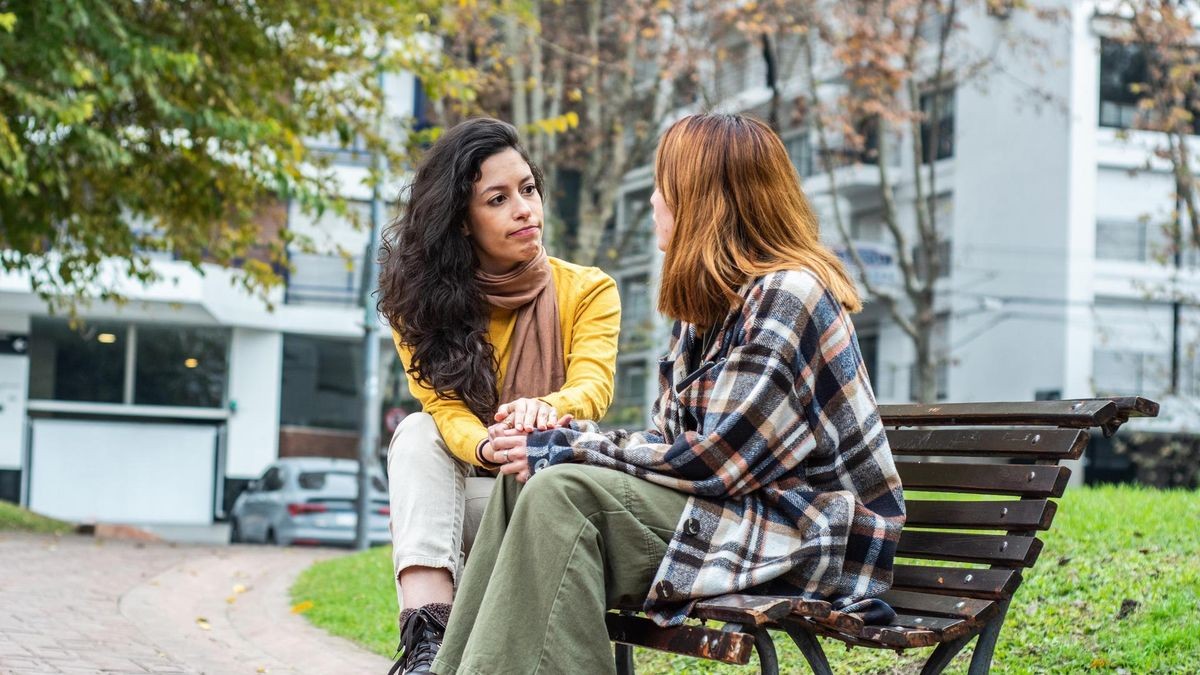 Young woman consoling her friend on the public park
