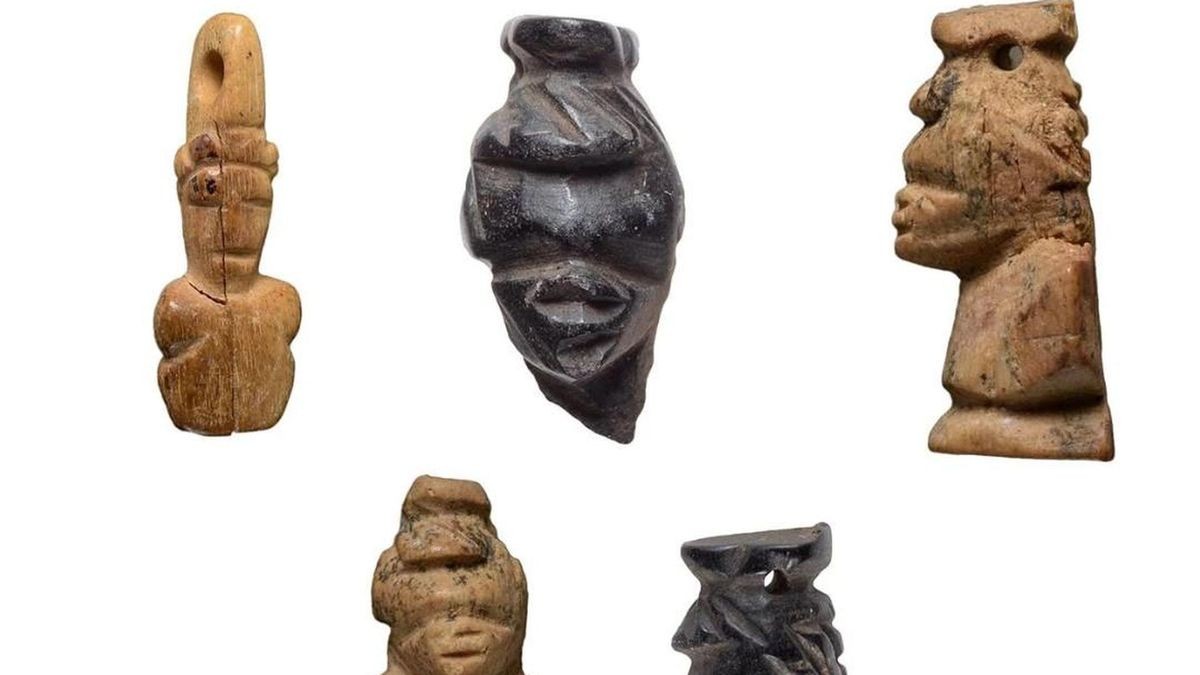 Fünf Holzfiguren vor einem weißen Hintergrund.
