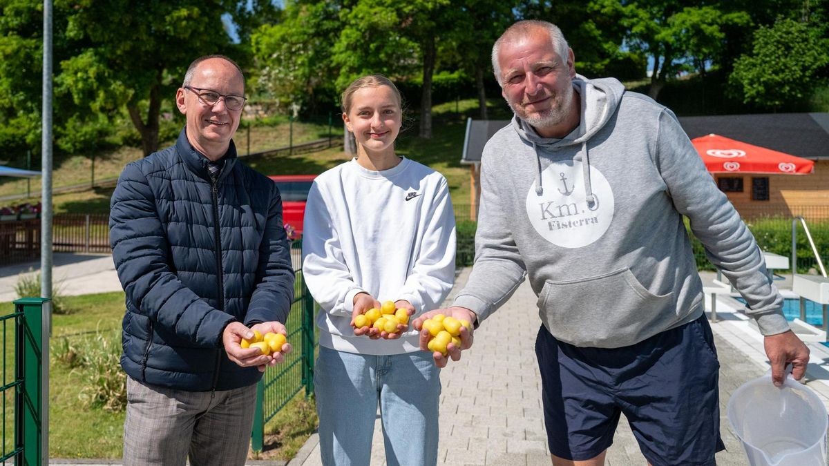 Kiosk-Betreiber Jens Andritzke (rechts), seine Nichte und Bürgermeister Michael Jahn (CDU) mit den Überraschungseiern, die kurz danach im Schwimmbecken landeten.
