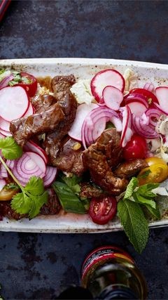 Asiatischer Salat mit Radieschen und Tomaten auf Chinakohl, dazu Rinderstreifen in würziger Soße