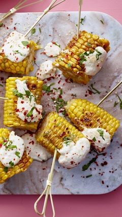 Steinbrettchen mit gebratenen Maisstücken, dazu Cashew-Aioli, garniert mit Chiliflocken