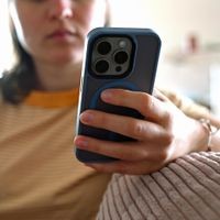 Smartphone-Nutzung gehört für viele Jugendliche zum Alltag – dabei können sie auch mit gefährlichen Inhalten in Berührung kommen. (Symbolbild) Eine junge Frau sitzt mit ihrem Smartphone auf dem Sofa und schaut auf das Display. Smartphone-Nutzung gehört für viele Jugendliche zum Alltag und ist oft Teil ihrer Freizeitgestaltung.