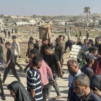 ARCHIV - 27.05.2025, Palästinensische Gebiete, Rafah: Ein mit einem Mobiltelefon aufgenommenes Bild zeigt Palästinenser nach der Entgegennahme von humanitärer Hilfe aus einer Hilfsgüterverteilungsstelle der von den USA unterstützten Gaza Humanitarian Foundation (GHF) in Rafah im südlichen Gazastreifen. (zu dpa: «Ringen um Gaza-Deal - Trump und Netanjahu sprachen erneut») Foto: Rizek Abdeljawad/XinHua/dpa +++ dpa-Bildfunk +++ Nahostkonflikt - Rafah