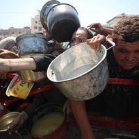 22.07.2025, Palästinensische Gebiete, Gaza: Menschen drängen sich, als eine Wohltätigkeitsorganisation warme Mahlzeiten an Palästinenser verteilt.
Die Menschen drängeln, um etwas vom Essen abzubekommen. (zu dpa: «Weinen vor Hunger») Foto: Omar Ashtawy/APA Images via ZUMA Press Wire/dpa - Honorarfrei nur für Bezieher des Dienstes dpa-Nachrichten für Kinder +++ dpa-Nachrichten für Kinder +++ Menschen halten im Gewühl Töpfe und Schlüsseln nach vorne.