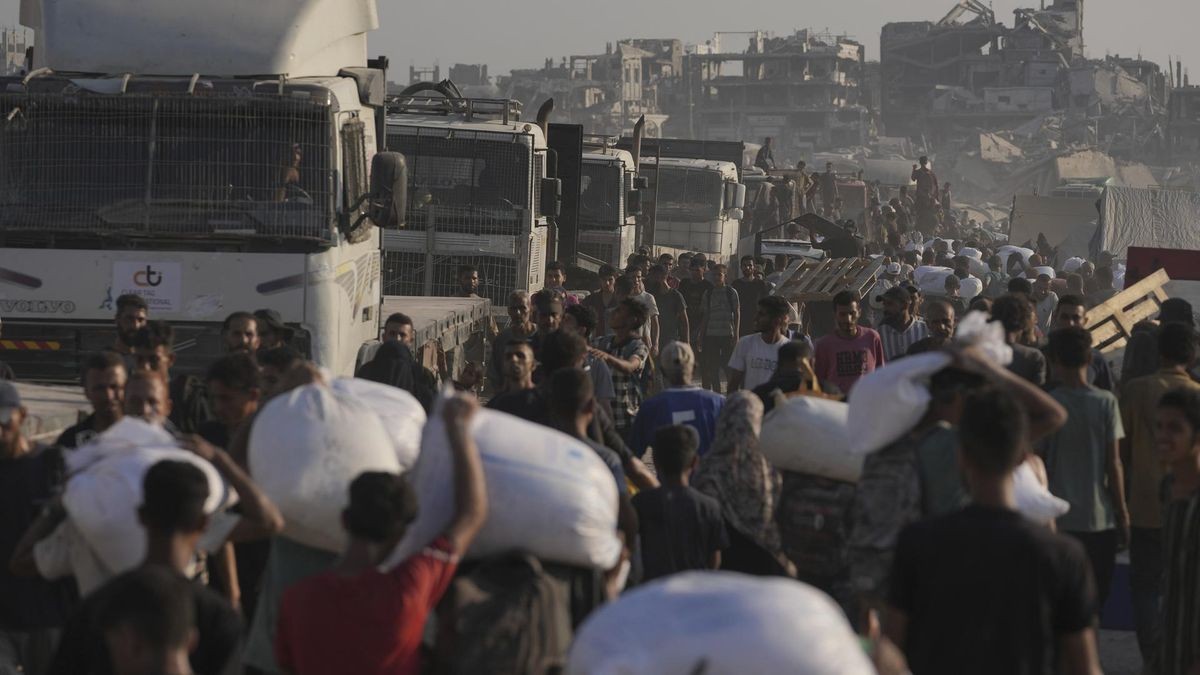 dpatopbilder - 26.07.2025, Palästinensische Gebiete, Gaza: Palästinenser tragen Mehlsäcke, die von einem humanitären Hilfskonvoi geliefert wurden, der Gaza-Stadt aus dem nördlichen Gazastreifen erreichte. Foto: Jehad Alshrafi/AP/dpa +++ dpa-Bildfunk +++