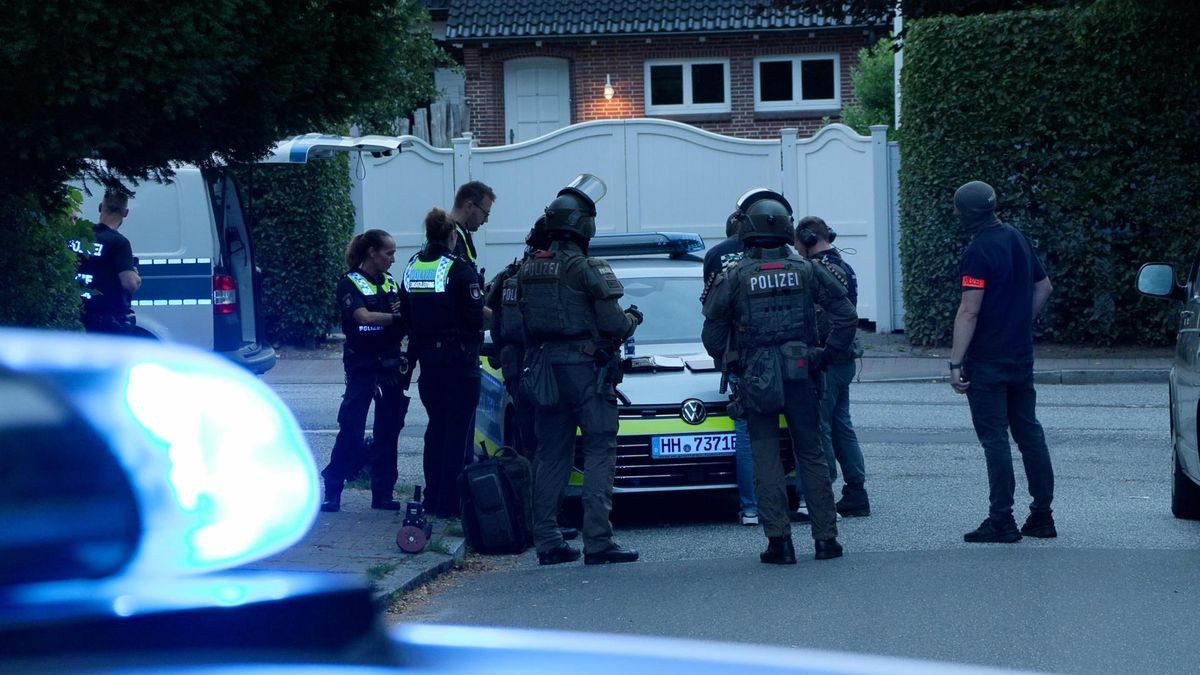 Schwer bewaffnete Spezialkräfte der Polizei Hamburg stehen in Blankenese auf einer Straße