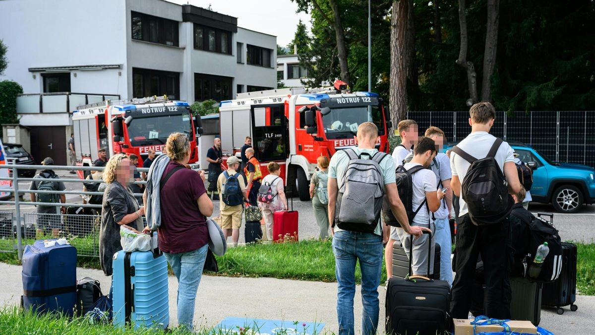 Zahlreiche Menschen stehen an einem Sammelplatz vor einem Bahnhof in Hadersdorf-Kammern