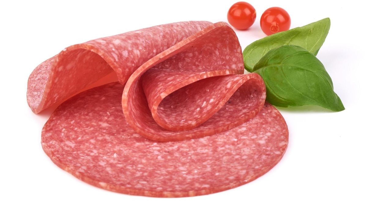 Smoked Italian sausage with basil leaves and Physalia berry. Isolated on a white background, Close-up.
