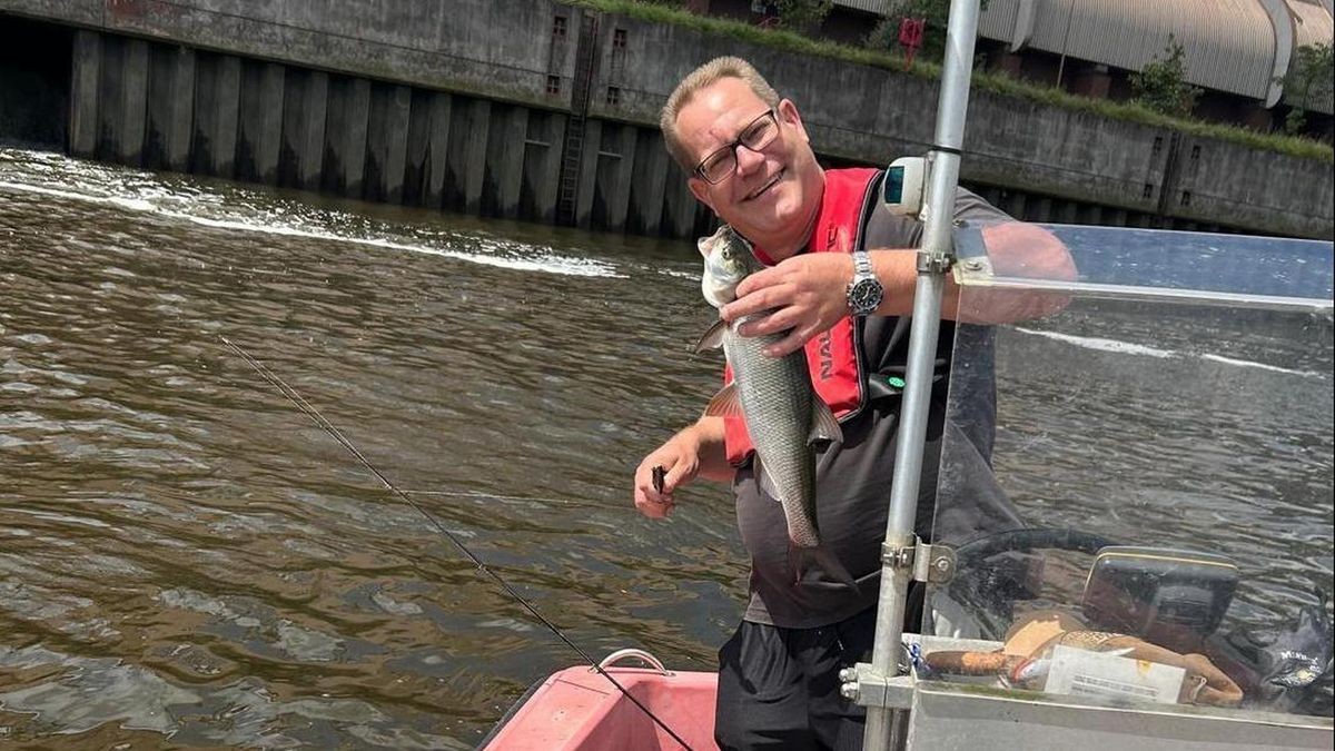 Elbfischer Christian von Stamm mit Fisch in der Hand auf Boot