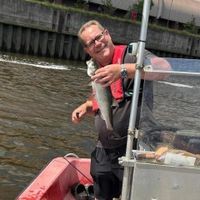 Elbfischer Christian von Stamm mit Fisch in der Hand auf Boot