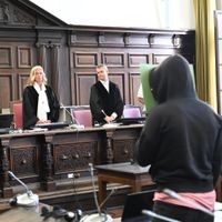 Mit einem Aktenordner verdeckt der Angeklagte bei Prozessauftakt vor dem Landgericht sein Gesicht. Die Staatsanwaltschaft wirft dem 25-Jährigen den Totschlag an seiner Mutter, den versuchten Mord an seiner Stiefmutter, gefährliche Körperverletzung sowie Körperverletzung mit tätlichem Angriff auf Vollstreckungsbeamte vor. Prozessauftakt Landgericht Hamburg