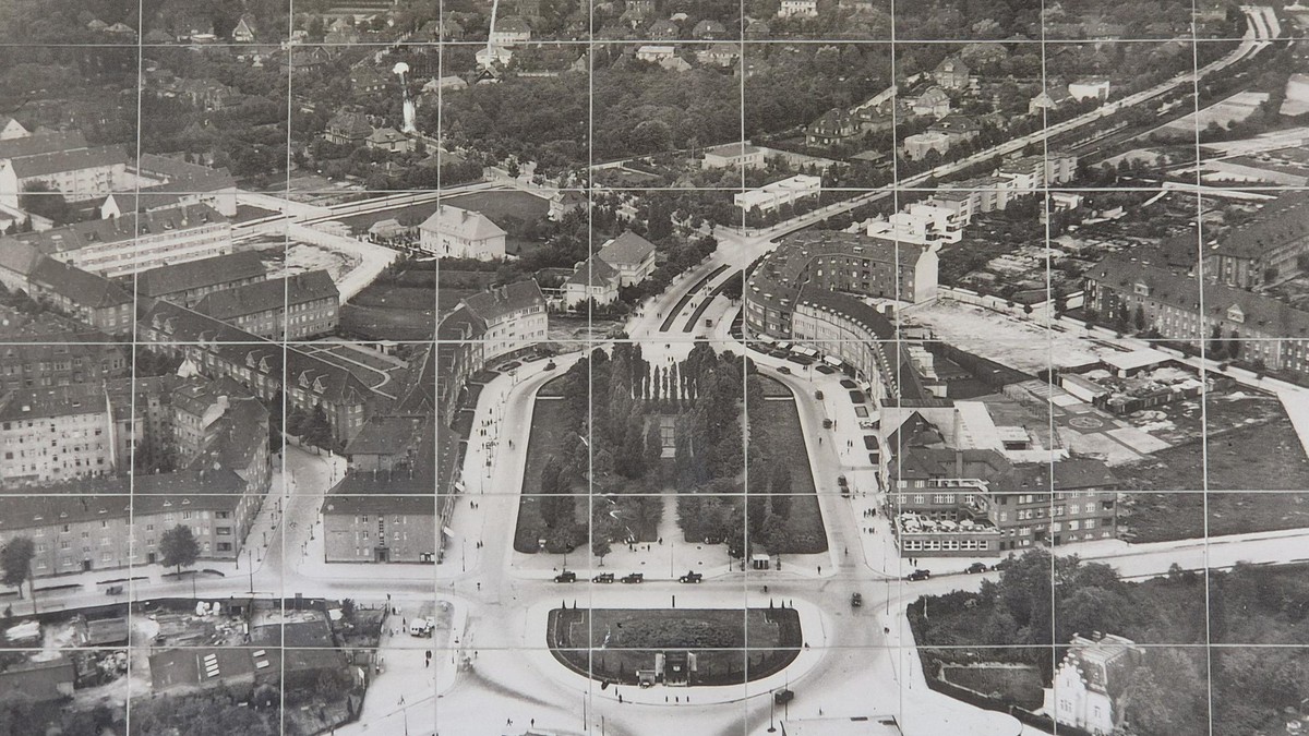 Das alte Foto vom Breitenbachplatz um 1930 hängt im U-Bahneingang. Zu sehen ist noch, dass der Platz mal ein Oval war. Breitenbachplatz, Lutz Pietschker von der Initiative Breitenbachplatz, die ihre Arbeit beendet