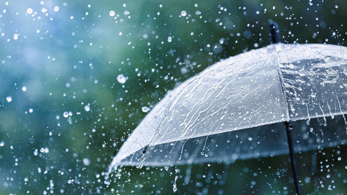 Transparent umbrella under rain against water drops splash background. Rainy weather concept.