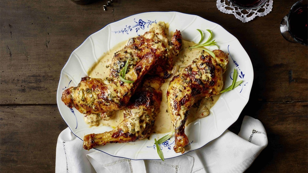 Teller mit vier Hähnchenschenkeln in Estragonsoße